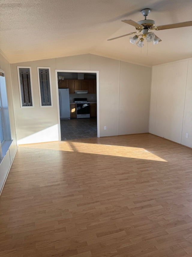 unfurnished room featuring dark wood-type flooring, ceiling fan, lofted ceiling, and a textured ceiling