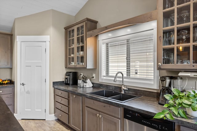 kitchen with sink, light hardwood / wood-style flooring, stainless steel dishwasher, and vaulted ceiling