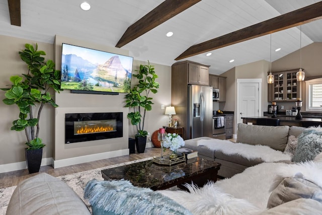 living room with light hardwood / wood-style floors and lofted ceiling with beams