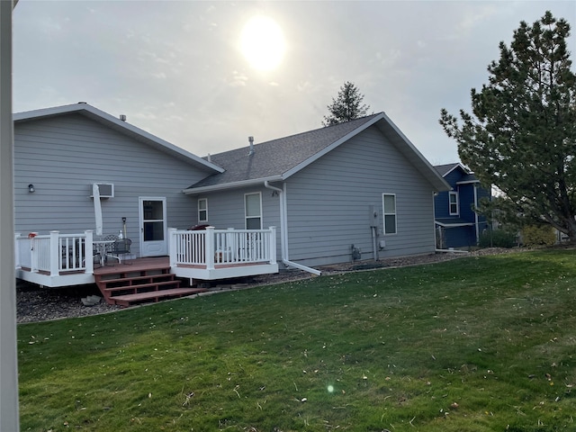 back of property featuring a wooden deck and a lawn