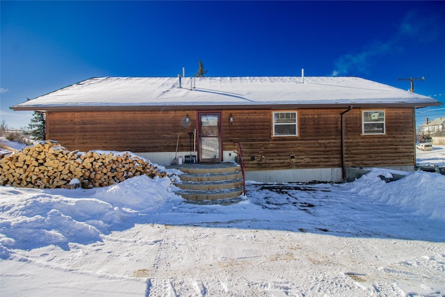 view of snow covered rear of property