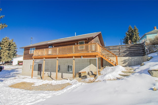 snow covered property with stairs and a deck