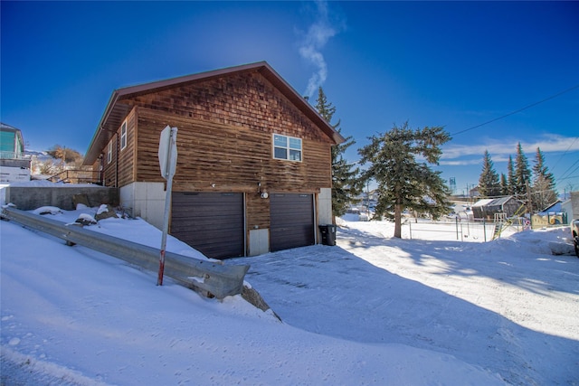 snow covered property with a garage