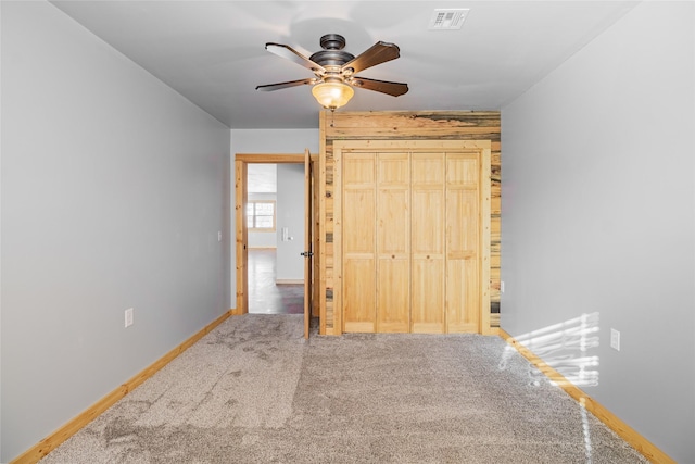 unfurnished bedroom with visible vents, a ceiling fan, a closet, carpet, and baseboards