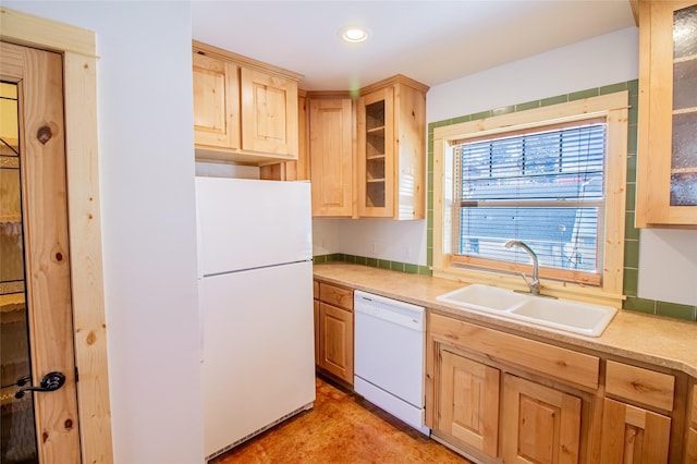 kitchen featuring light brown cabinets, white appliances, light countertops, and a sink