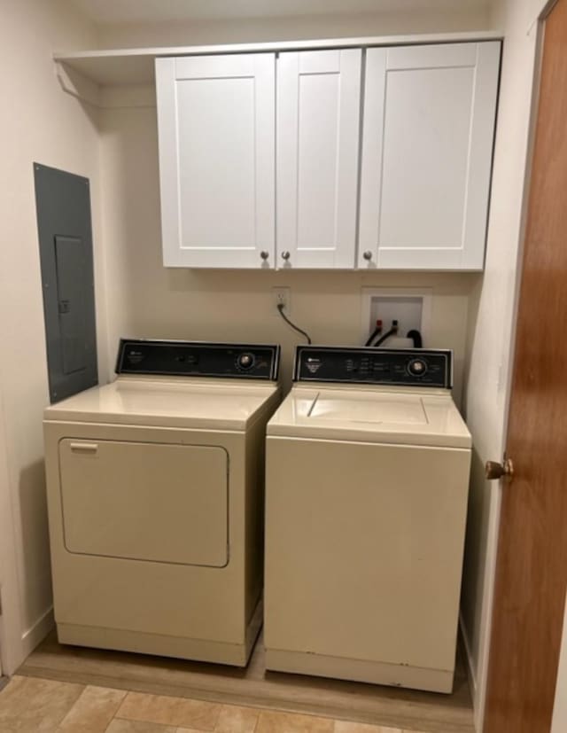 washroom featuring cabinets, washing machine and dryer, and electric panel