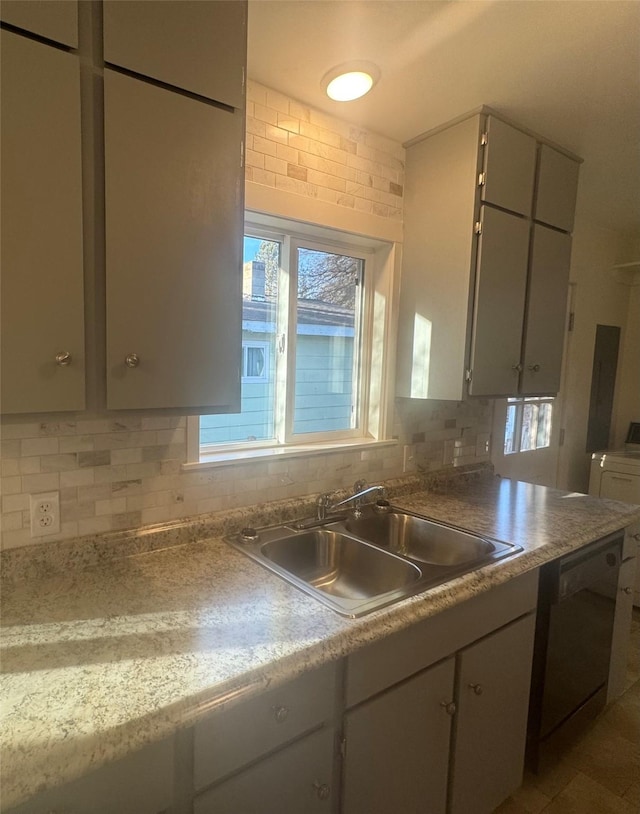 kitchen with sink, gray cabinets, dishwasher, washer / dryer, and decorative backsplash