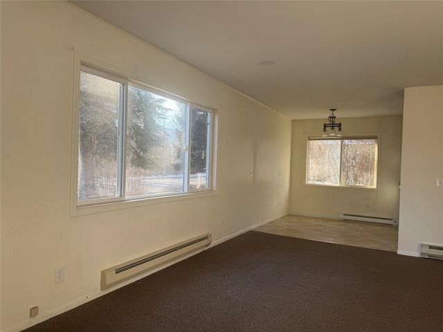 carpeted spare room featuring a baseboard radiator