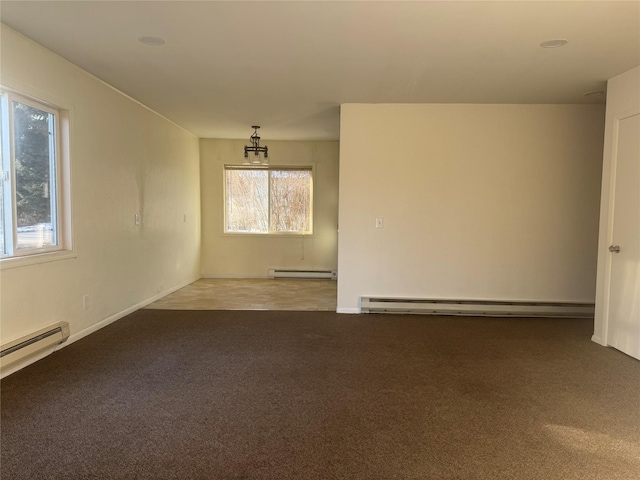 carpeted empty room with a healthy amount of sunlight and baseboard heating