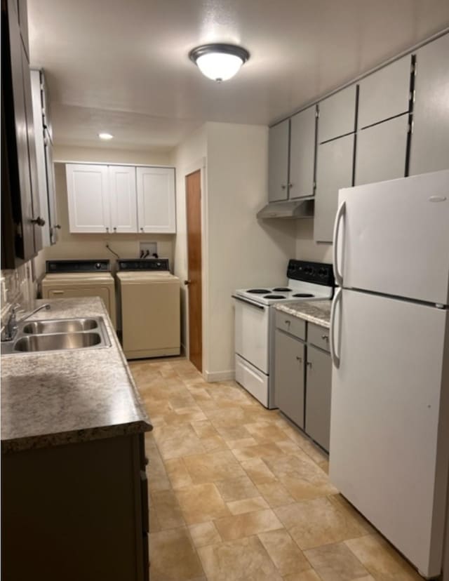 kitchen featuring white cabinets, sink, washing machine and clothes dryer, and white appliances