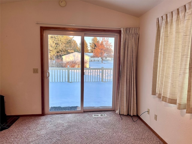 entryway featuring vaulted ceiling, carpet flooring, and a healthy amount of sunlight