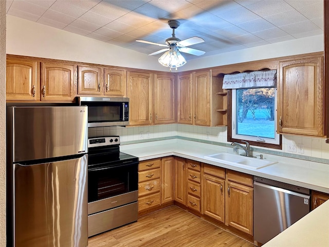 kitchen featuring sink, decorative backsplash, light hardwood / wood-style flooring, and stainless steel appliances