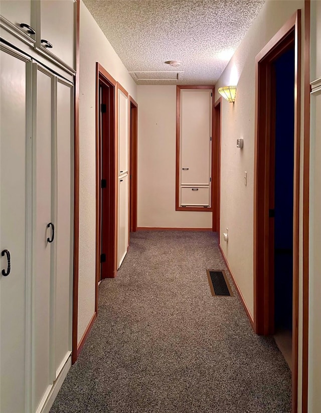 corridor with carpet floors and a textured ceiling