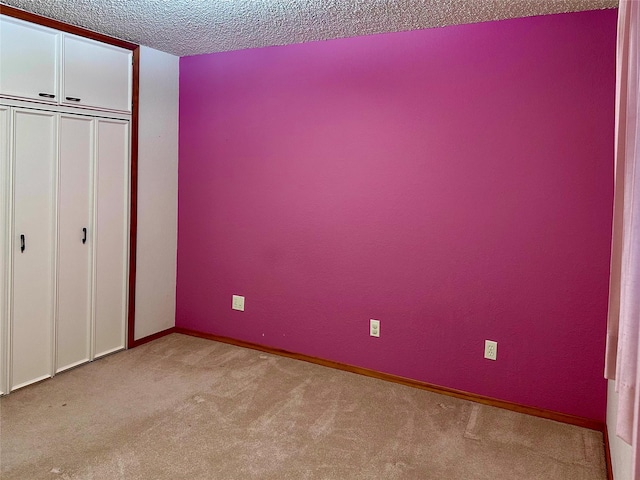 unfurnished bedroom with light carpet, a closet, and a textured ceiling