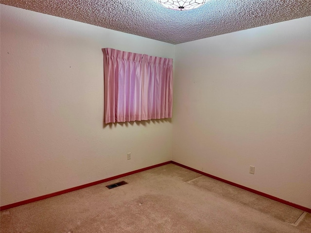 carpeted spare room featuring a textured ceiling