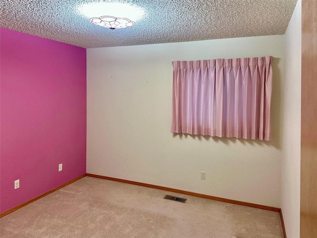 empty room featuring carpet and a textured ceiling