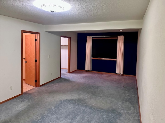 unfurnished room featuring a textured ceiling and carpet flooring