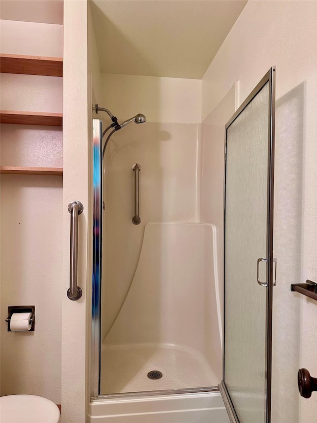 bathroom with walk in shower and toilet