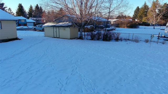 yard covered in snow with a shed