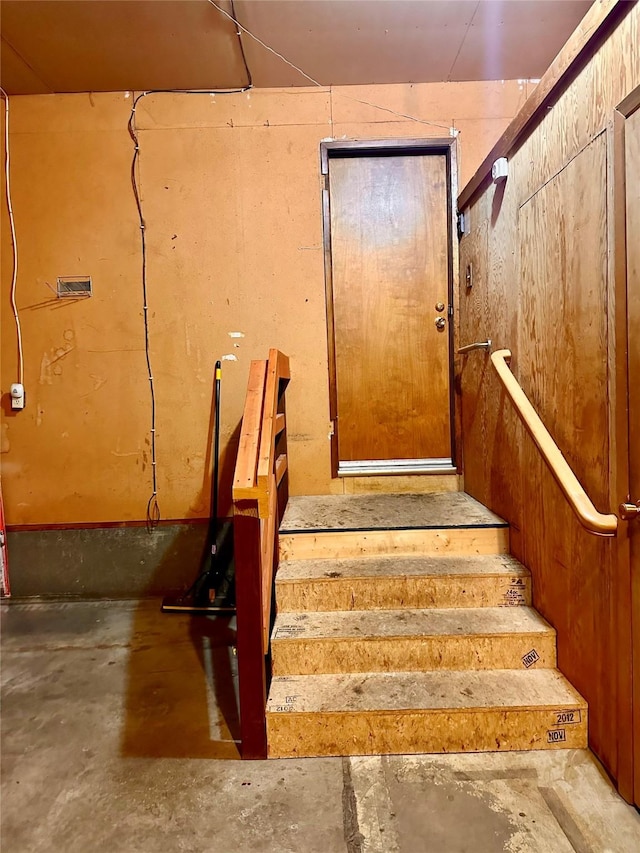 staircase featuring concrete floors