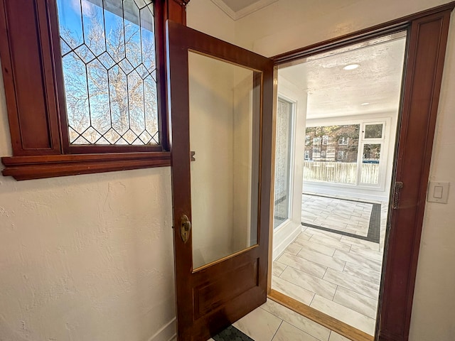 doorway to outside with light tile patterned flooring and a textured ceiling