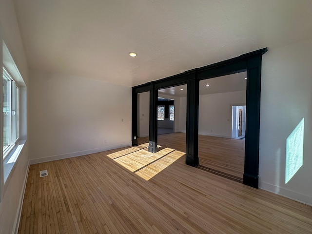 spare room featuring hardwood / wood-style flooring and a wealth of natural light