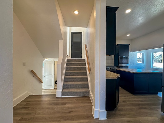 stairs featuring hardwood / wood-style flooring and a textured ceiling