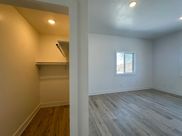 walk in closet with light hardwood / wood-style floors