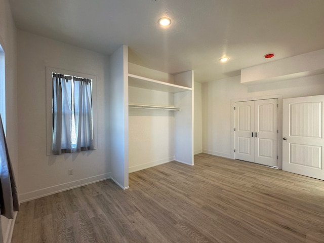 unfurnished bedroom featuring hardwood / wood-style floors and a closet