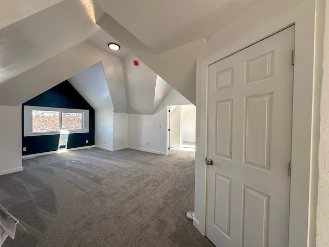 additional living space featuring lofted ceiling and carpet