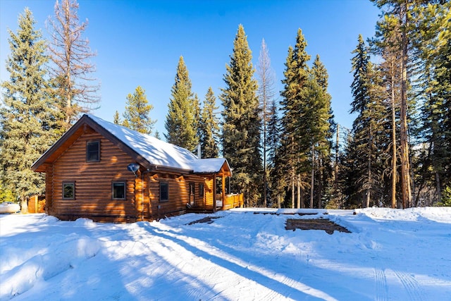 snow covered property featuring log siding