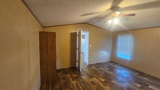 unfurnished room with vaulted ceiling, dark wood-type flooring, a textured ceiling, and ceiling fan