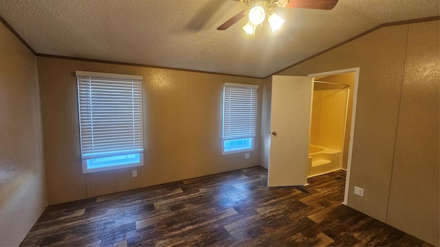 unfurnished bedroom with crown molding, vaulted ceiling, a textured ceiling, dark hardwood / wood-style floors, and ceiling fan