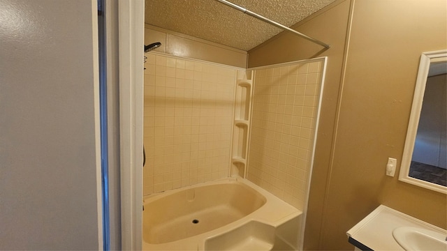 bathroom with vanity,  shower combination, and a textured ceiling