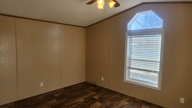 empty room with lofted ceiling, ceiling fan, dark wood-type flooring, and a textured ceiling