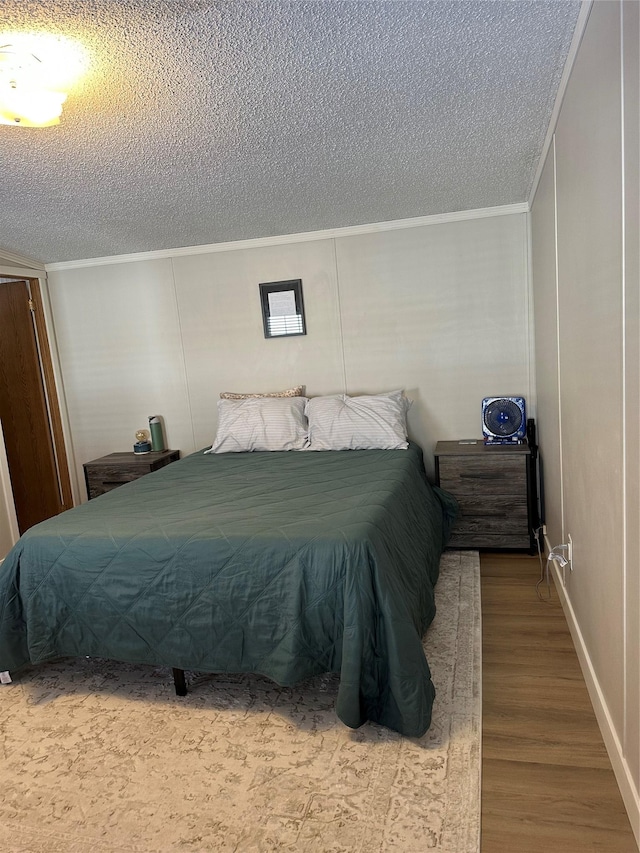 bedroom with hardwood / wood-style flooring and a textured ceiling