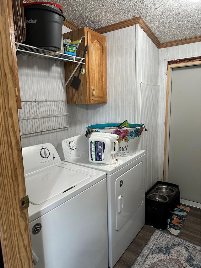 laundry room with dark wood-type flooring, crown molding, cabinets, separate washer and dryer, and a textured ceiling