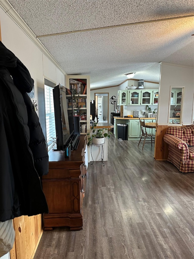 living room with hardwood / wood-style floors, crown molding, vaulted ceiling, and a textured ceiling