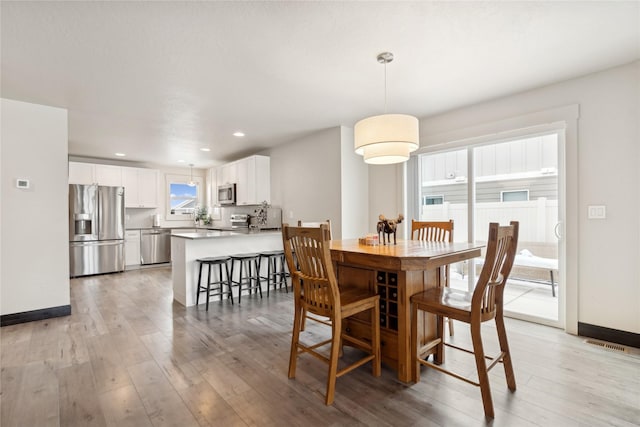 dining space with light hardwood / wood-style floors