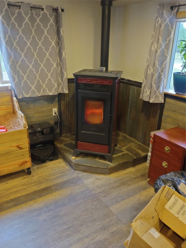 interior details featuring a wood stove, hardwood / wood-style floors, and wooden walls