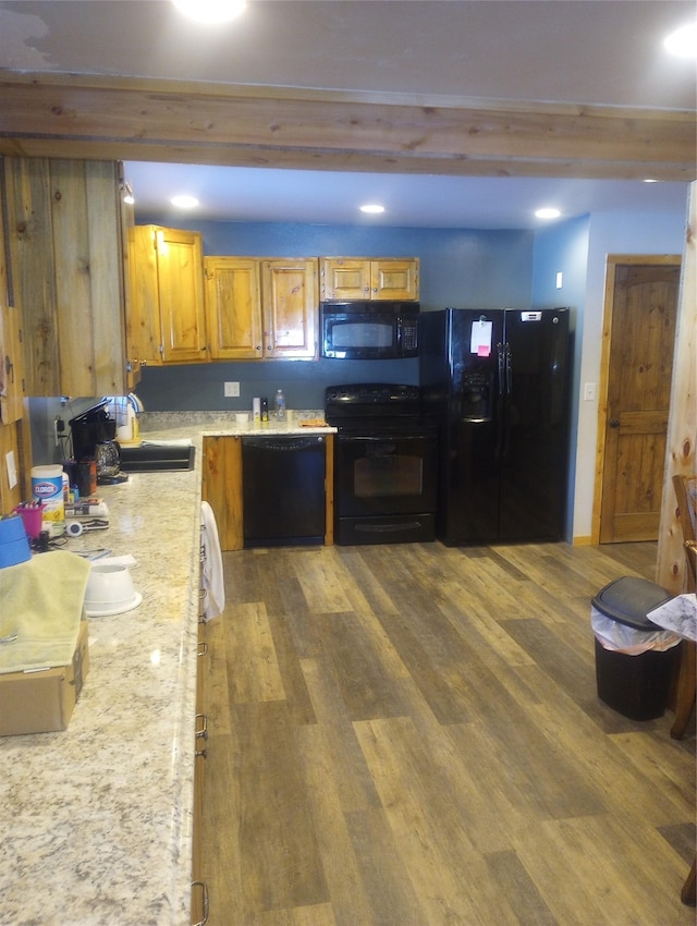 kitchen featuring dark wood-type flooring, sink, and black appliances