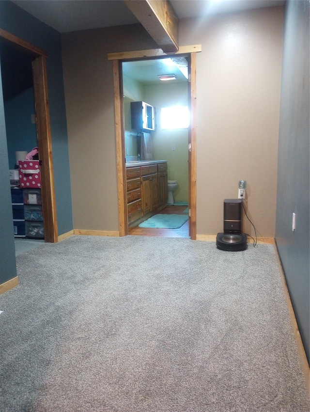 bedroom featuring ensuite bath and carpet floors