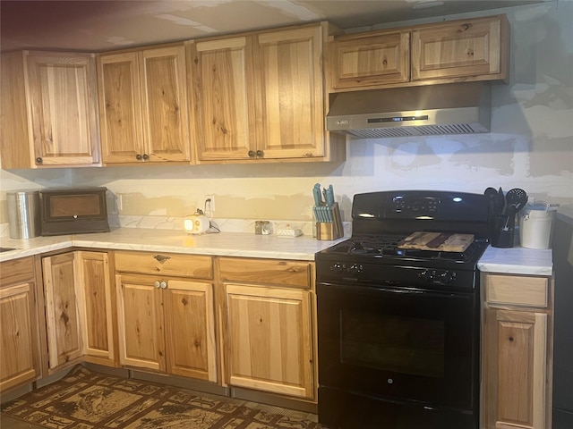 kitchen with black gas range oven and exhaust hood