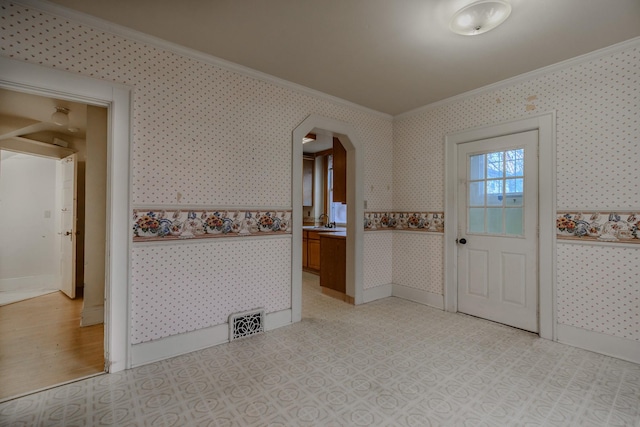 entryway featuring ornamental molding and sink