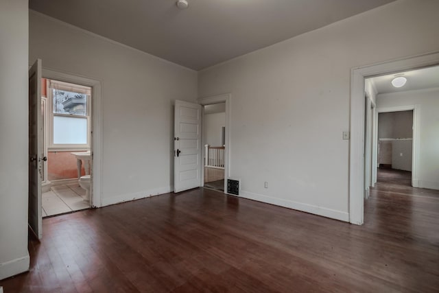 unfurnished bedroom with dark hardwood / wood-style flooring and connected bathroom