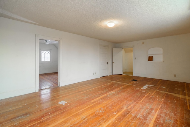 empty room featuring wood-type flooring and a textured ceiling