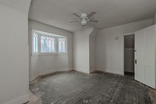 spare room with dark hardwood / wood-style flooring, ceiling fan, and a textured ceiling