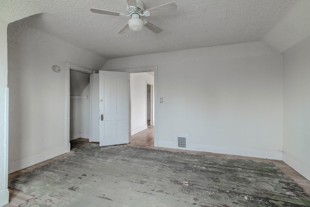 interior space with lofted ceiling, a textured ceiling, a closet, and ceiling fan