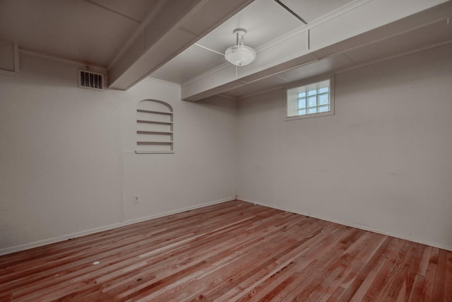 basement featuring light hardwood / wood-style floors and built in shelves