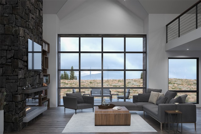 living room with wood-type flooring, a stone fireplace, a wealth of natural light, and high vaulted ceiling